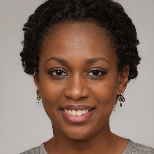 Joyful black young-adult female with short  black hair and brown eyes