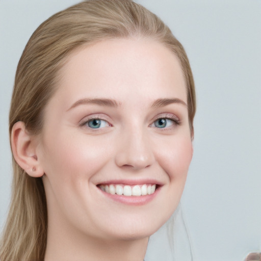 Joyful white young-adult female with long  brown hair and blue eyes