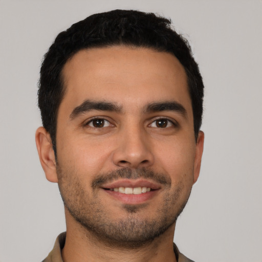 Joyful latino young-adult male with short  black hair and brown eyes