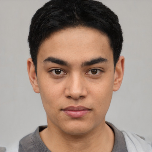 Joyful latino young-adult male with short  black hair and brown eyes