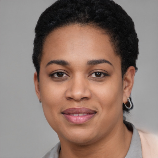 Joyful black young-adult female with short  black hair and brown eyes