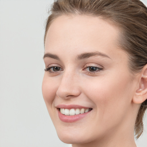 Joyful white young-adult female with long  brown hair and blue eyes