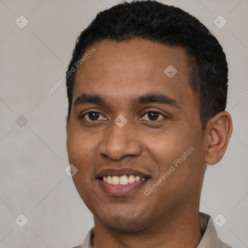 Joyful black young-adult male with short  black hair and brown eyes