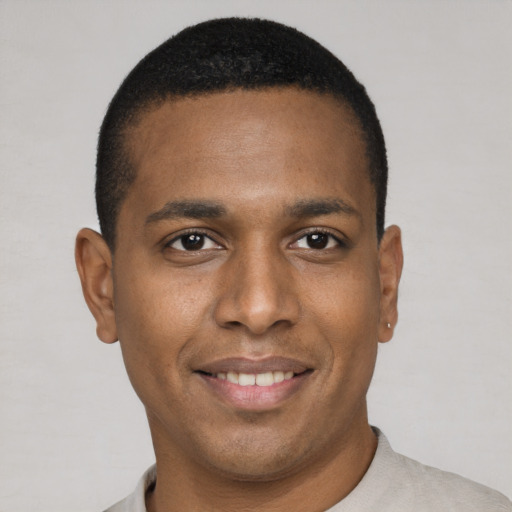 Joyful black young-adult male with short  brown hair and brown eyes