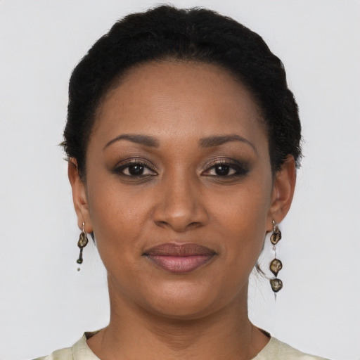 Joyful black young-adult female with short  black hair and brown eyes