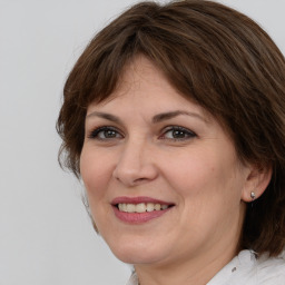 Joyful white adult female with medium  brown hair and brown eyes