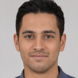 Joyful white young-adult male with short  black hair and brown eyes
