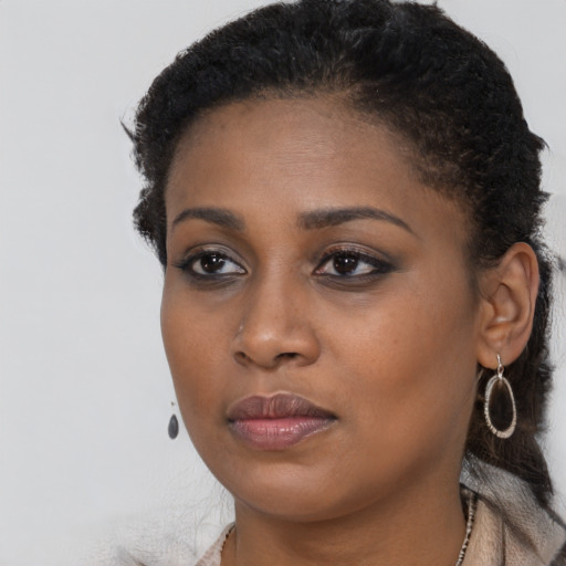 Joyful black young-adult female with long  brown hair and brown eyes