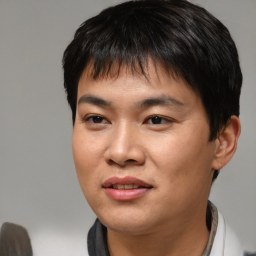 Joyful asian young-adult male with short  brown hair and brown eyes