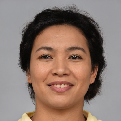 Joyful asian adult female with medium  brown hair and brown eyes
