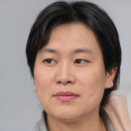 Joyful asian adult female with medium  brown hair and brown eyes