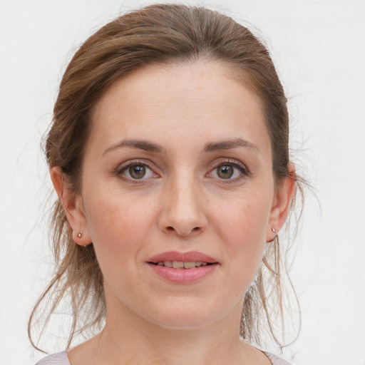 Joyful white young-adult female with medium  brown hair and grey eyes