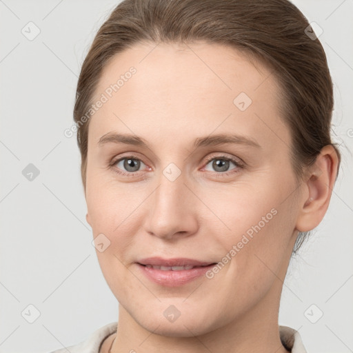 Joyful white young-adult female with medium  brown hair and grey eyes