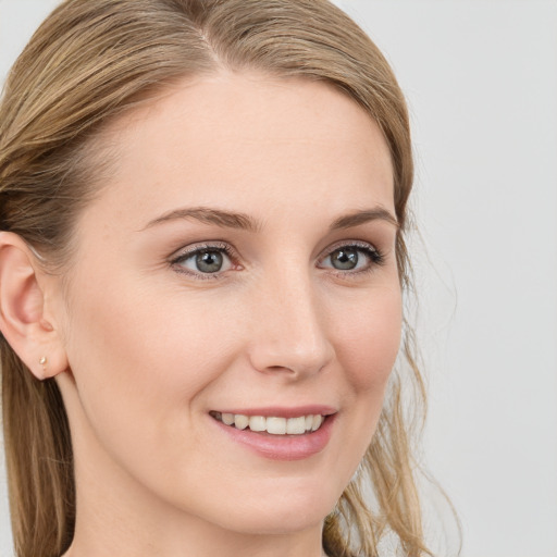 Joyful white young-adult female with long  brown hair and blue eyes