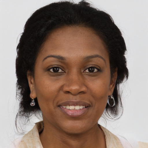 Joyful black adult female with long  brown hair and brown eyes