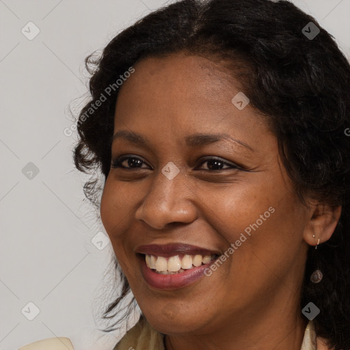 Joyful black young-adult female with long  brown hair and brown eyes