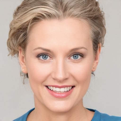 Joyful white young-adult female with medium  brown hair and blue eyes