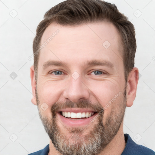 Joyful white adult male with short  brown hair and grey eyes