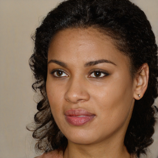 Joyful black young-adult female with long  brown hair and brown eyes