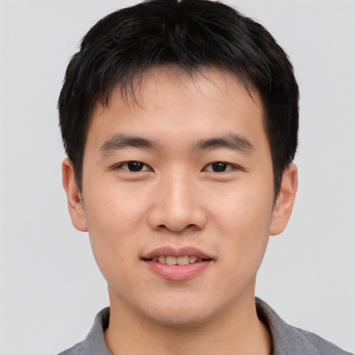 Joyful asian young-adult male with short  black hair and brown eyes