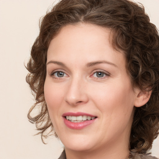 Joyful white young-adult female with medium  brown hair and green eyes