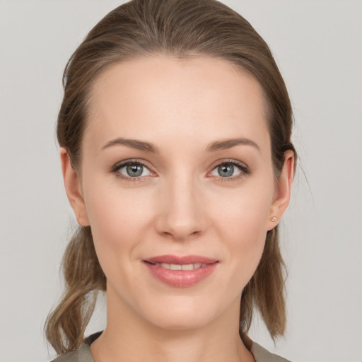 Joyful white young-adult female with medium  brown hair and grey eyes