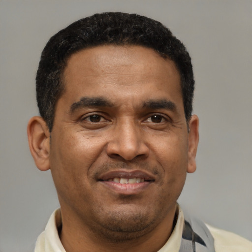 Joyful latino adult male with short  brown hair and brown eyes