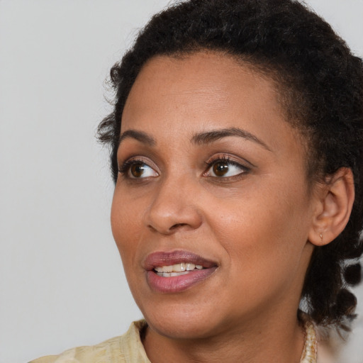 Joyful black young-adult female with short  brown hair and brown eyes