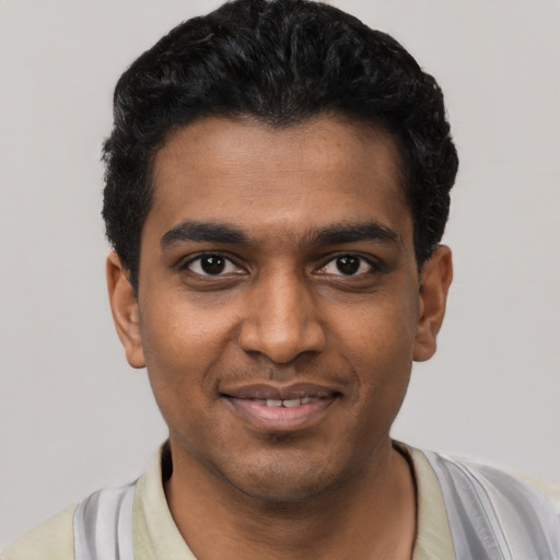Joyful black young-adult male with short  black hair and brown eyes