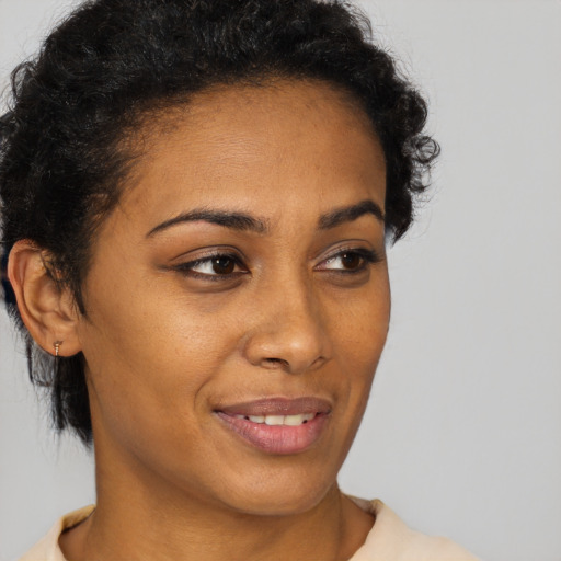 Joyful black young-adult female with short  brown hair and brown eyes