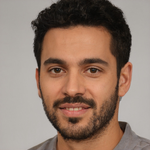Joyful white young-adult male with short  black hair and brown eyes
