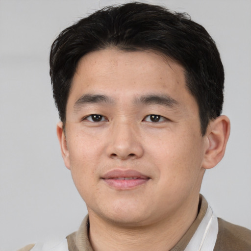 Joyful asian young-adult male with short  brown hair and brown eyes