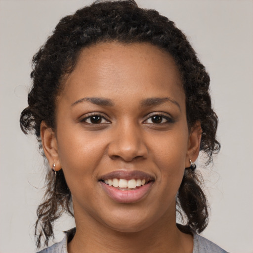 Joyful black young-adult female with medium  brown hair and brown eyes