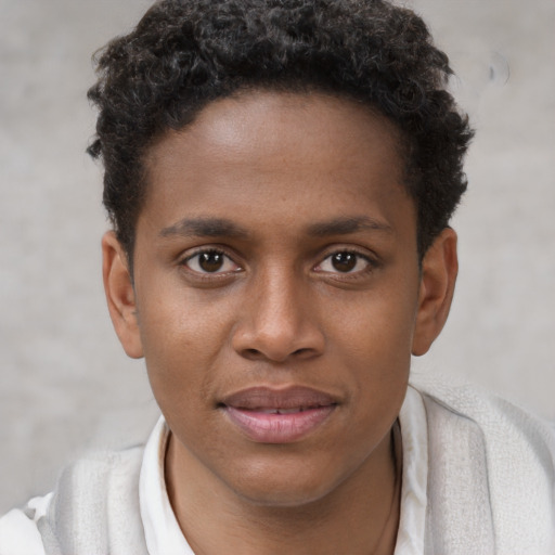 Joyful black young-adult male with short  brown hair and brown eyes