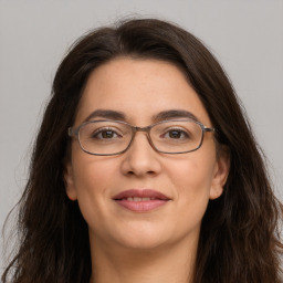 Joyful white adult female with long  brown hair and brown eyes