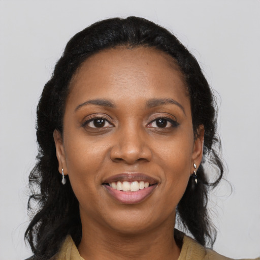 Joyful black young-adult female with long  black hair and brown eyes