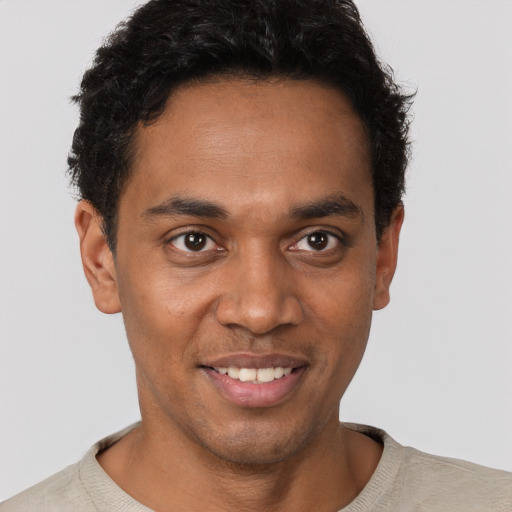 Joyful black young-adult male with short  brown hair and brown eyes