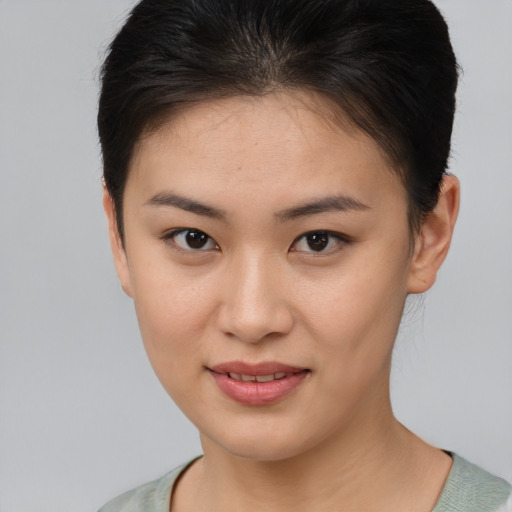 Joyful asian young-adult female with short  brown hair and brown eyes