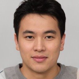 Joyful asian young-adult male with short  brown hair and brown eyes