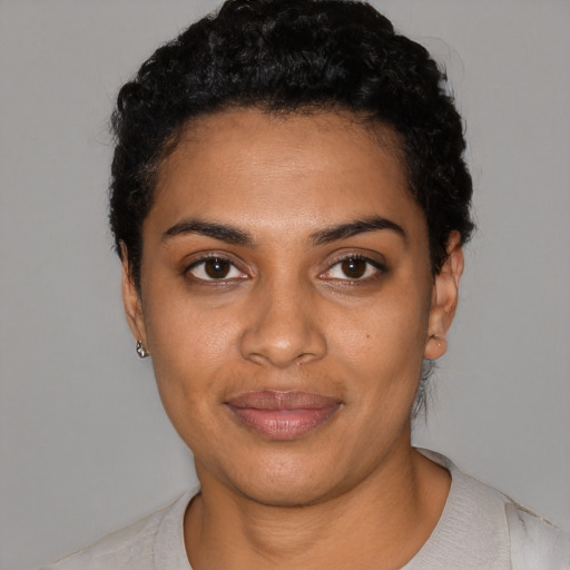 Joyful black young-adult female with short  black hair and brown eyes