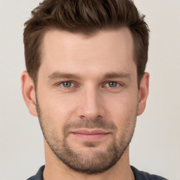 Joyful white young-adult male with short  brown hair and grey eyes