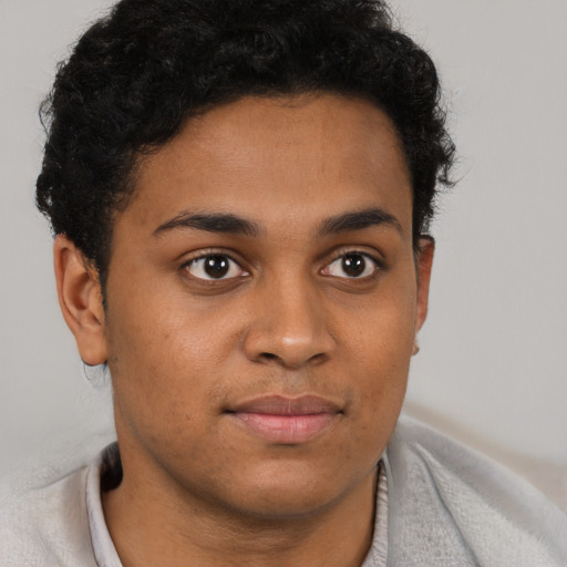 Joyful latino young-adult male with short  brown hair and brown eyes