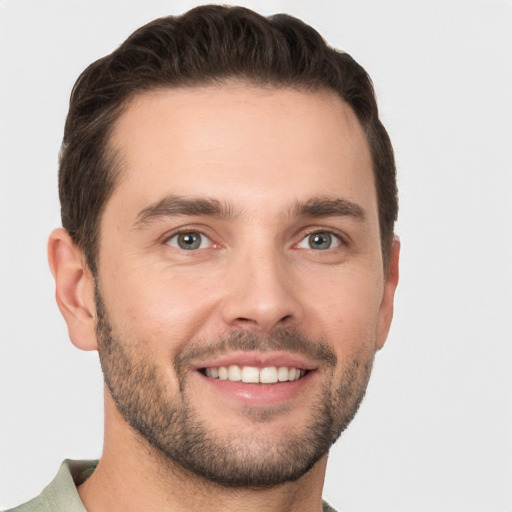 Joyful white young-adult male with short  brown hair and grey eyes