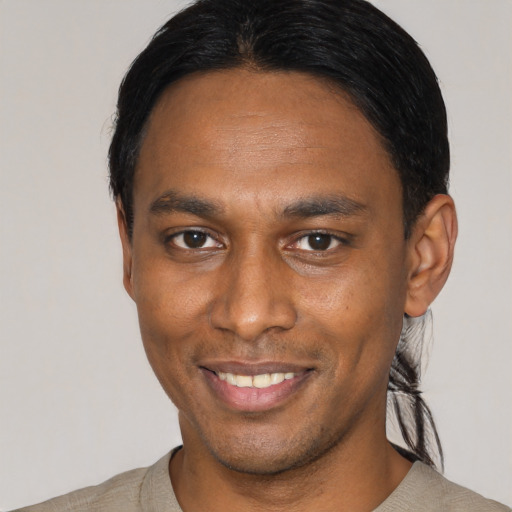 Joyful latino young-adult male with short  black hair and brown eyes