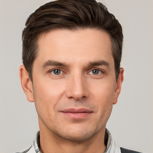 Joyful white young-adult male with short  brown hair and grey eyes