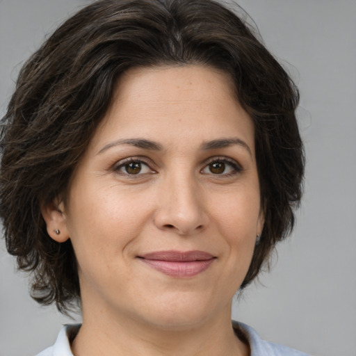 Joyful white adult female with medium  brown hair and brown eyes