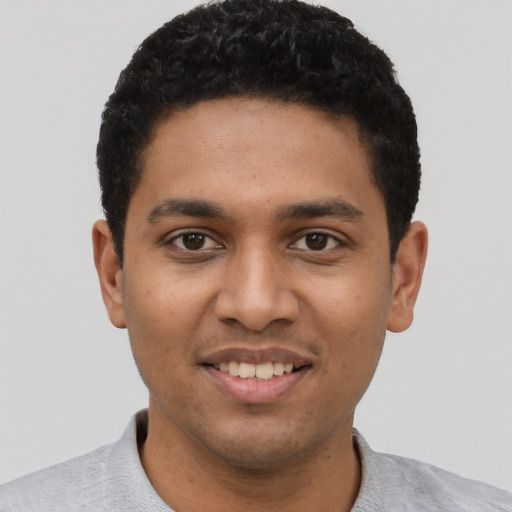 Joyful black young-adult male with short  black hair and brown eyes