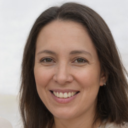 Joyful white adult female with long  brown hair and grey eyes