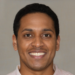 Joyful latino young-adult male with short  brown hair and brown eyes