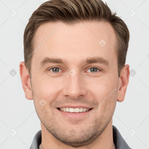 Joyful white young-adult male with short  brown hair and grey eyes